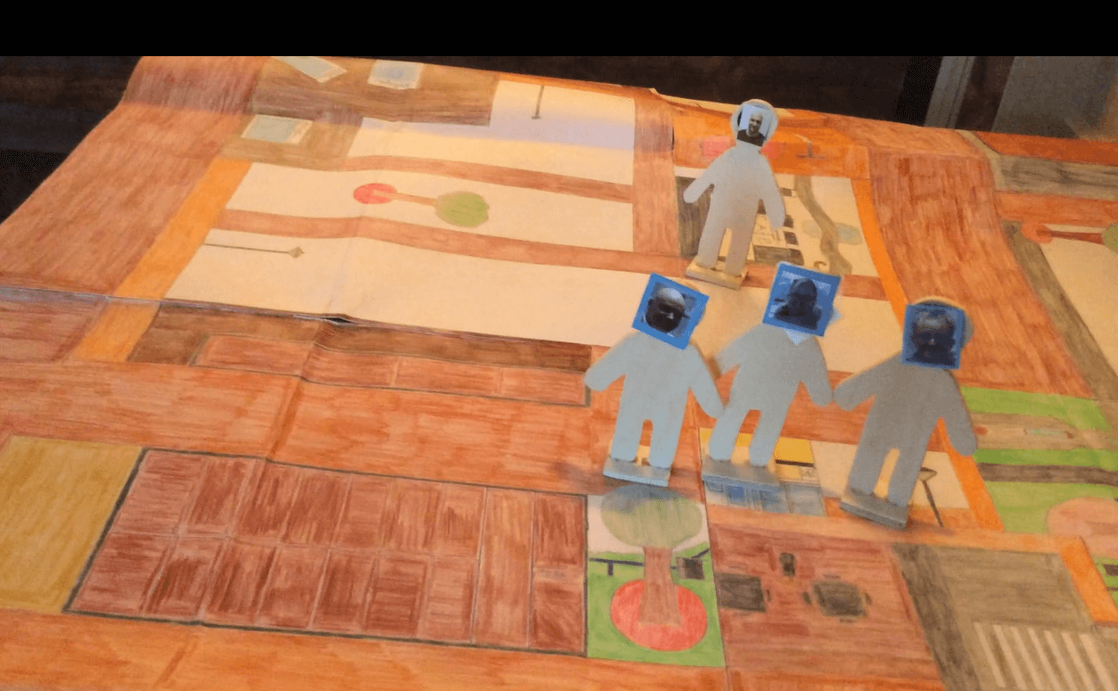 Bewoner P navigeert met zijn houten poppetjes over de plattegrond van Waubach